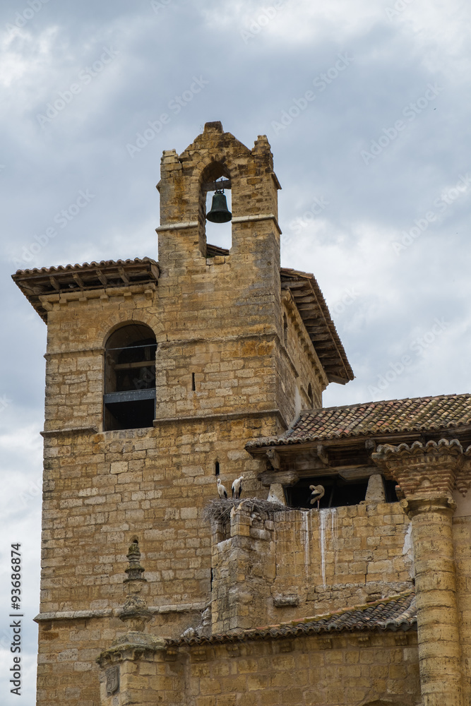 Vista de unos nidos de cigueñas junto al campanario de una iglesia del románico