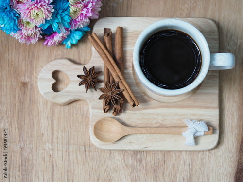 black coffee cup and cinnamon with spicy herb on wooden tray