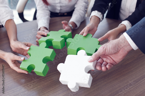 Business people assembling puzzle