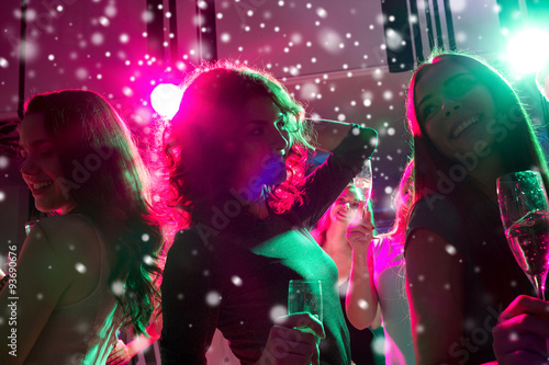 smiling friends with glasses of champagne in club