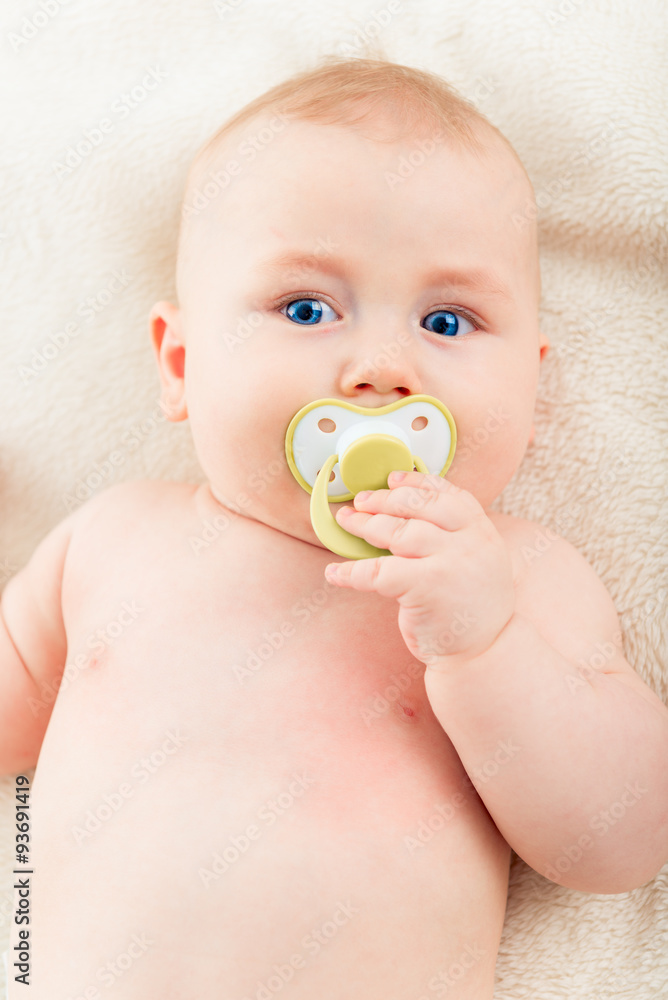 Portrait of an adorable baby with a pacifier in his mouth. Portrait of an adorable baby with a pacifier in his mouth.