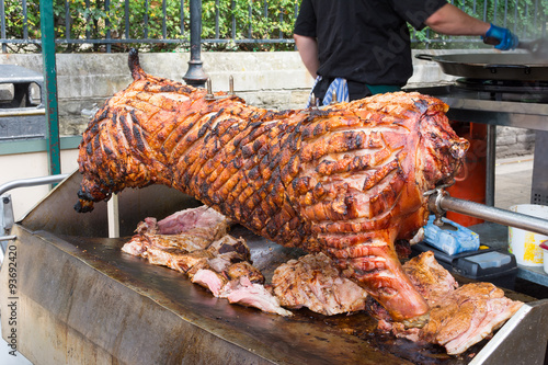 Spit roasting pork with succulent crackling ready for carving.