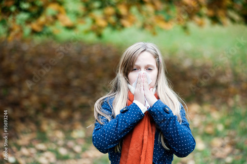 Girl with a handkerchief blowing her nose