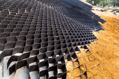 Fotografie Slope erosion control with grids and earth on steep slope