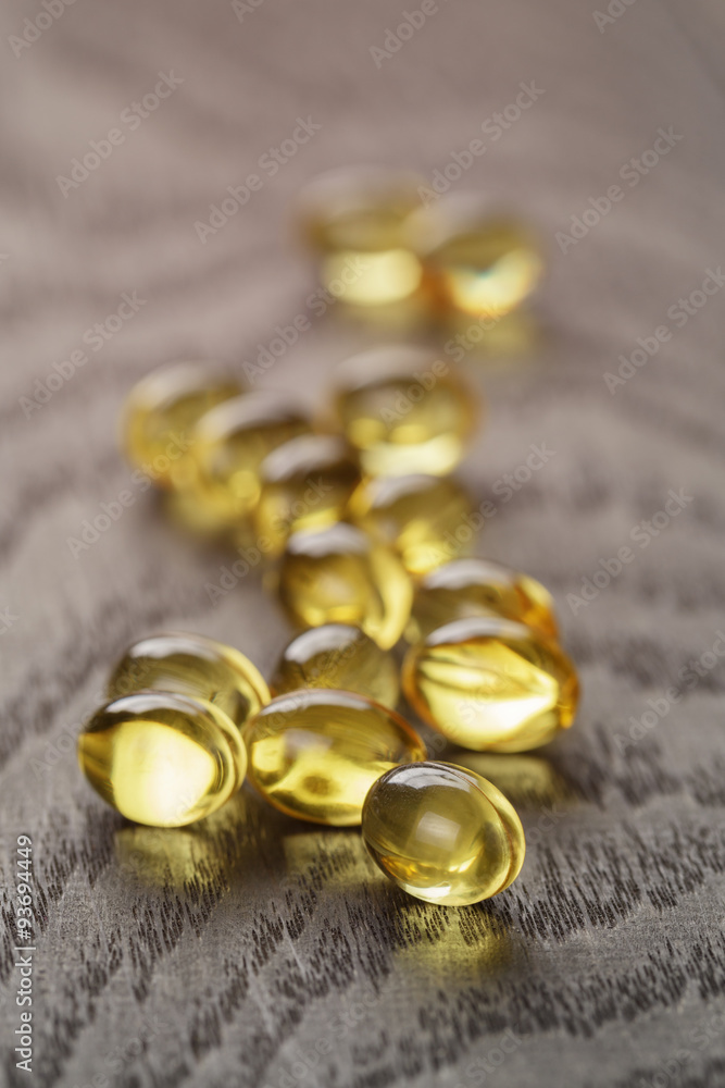 fish oil capsules on wooden tabe fish oil capsules on wooden tabe