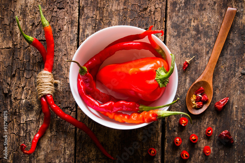 cayenne red pepper in a white plate on a wooden table spoon with spices