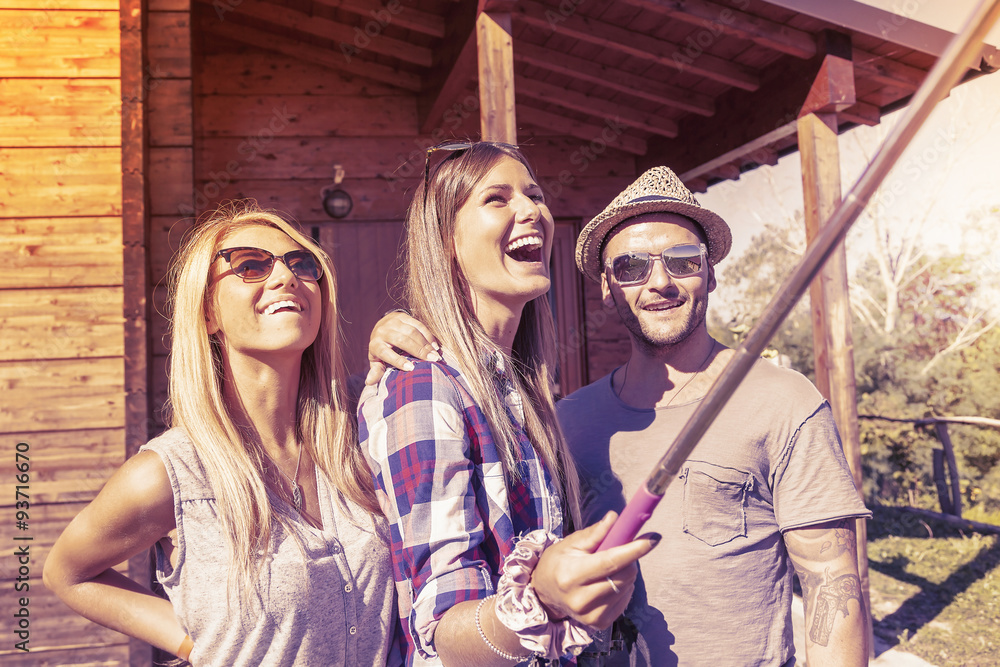 group of smiling friends taking funny selfie with smart phone group of smiling friends taking funny selfie with smart phone