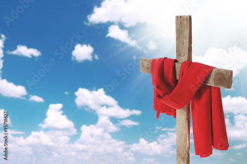 Cross with red cloth on sky background photo