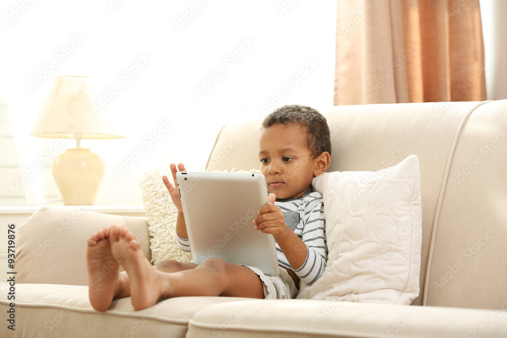Little boy sitting on sofa with tablet in the room Little boy sitting on sofa with tablet in the room