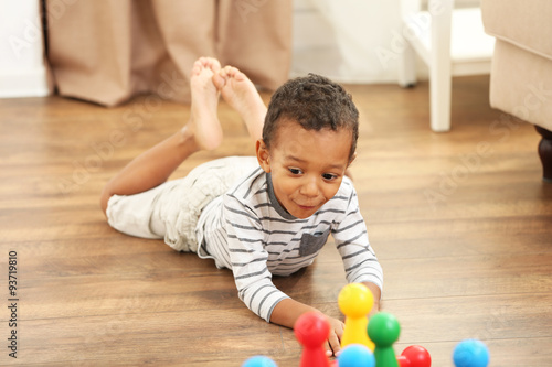 Little boy playing bowling in the room