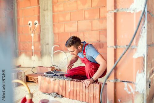 stonemason builing walls, construction engineer and worker on site photo