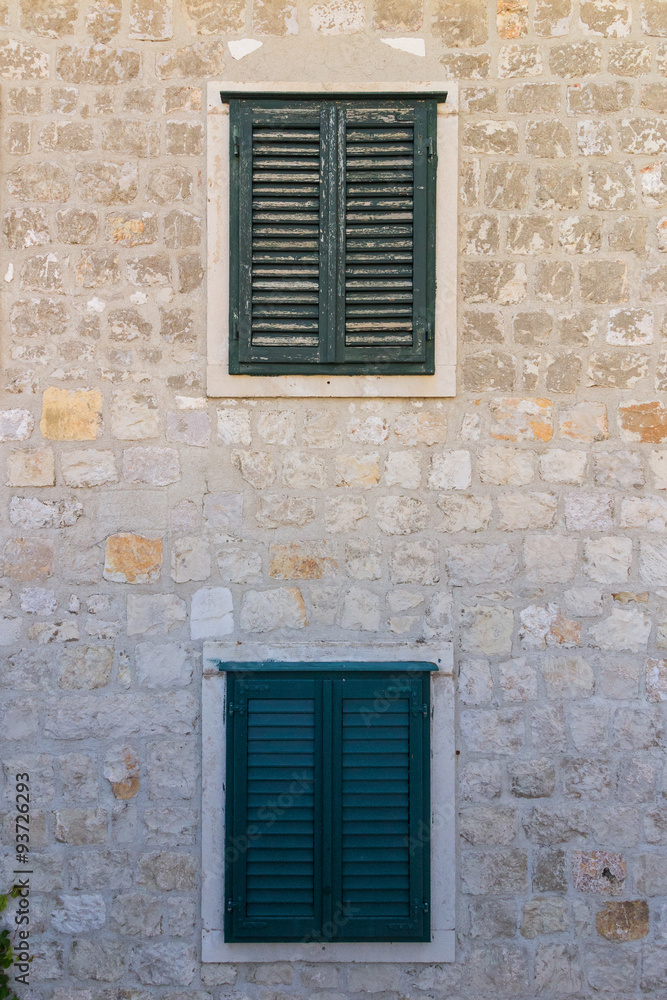 Old windows with blinds and stone wall at the Old Town in Dubrovnik, Croatia.