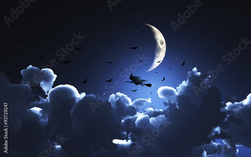 Halloween background with witch flying through a moonlit sky photo