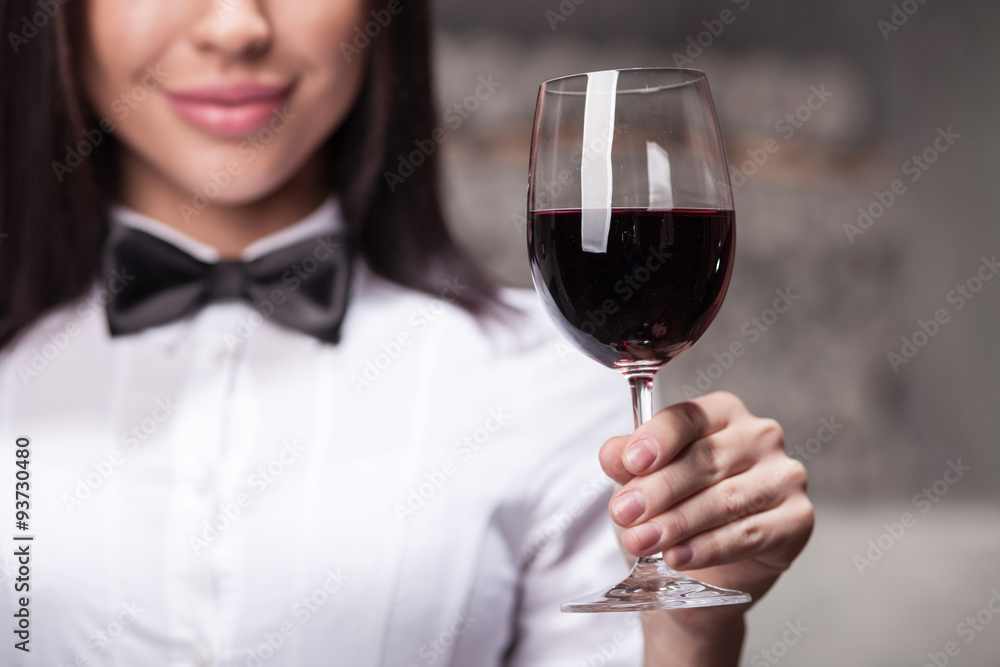 Close-up cute female sommelier is choosing perfect drink Close-up cute female sommelier is choosing perfect drink