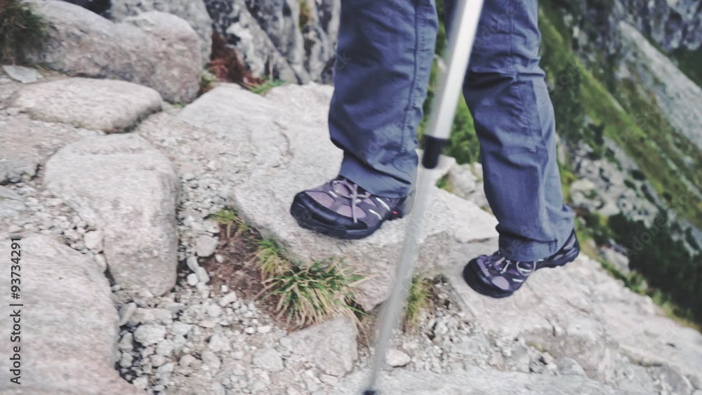 Hiking - hiker woman on trek, living healthy active lifestyle. Close up on feet. Slow Motion. Strong woman legs walking on mountain trail. Epic Storm Weather and rocks. Misty Mountains Series. Hiking - hiker woman on trek, living healthy active lifestyle. Close up on feet. Slow Motion. Strong woman legs walking on mountain trail. Epic Storm Weather and rocks. Misty Mountains Series.