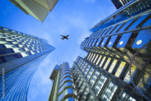 A jet airplane silhouette with business office towers background