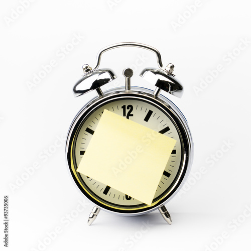 Alarm clock with sticky paper note on white background