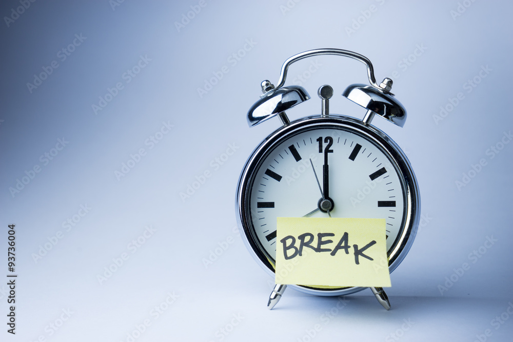 Alarm clock with sticky paper note on white background..