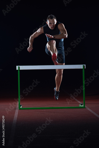 athlete jumping over a hurdles