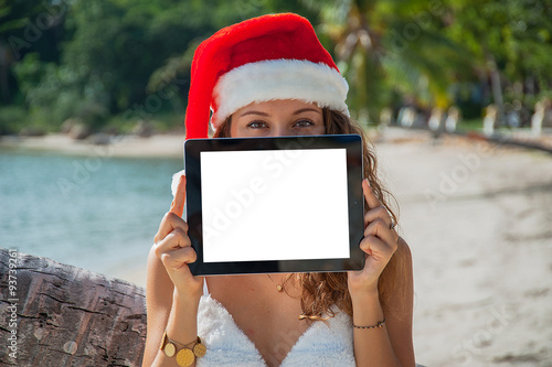 A woman in a christmas hat with a tablet