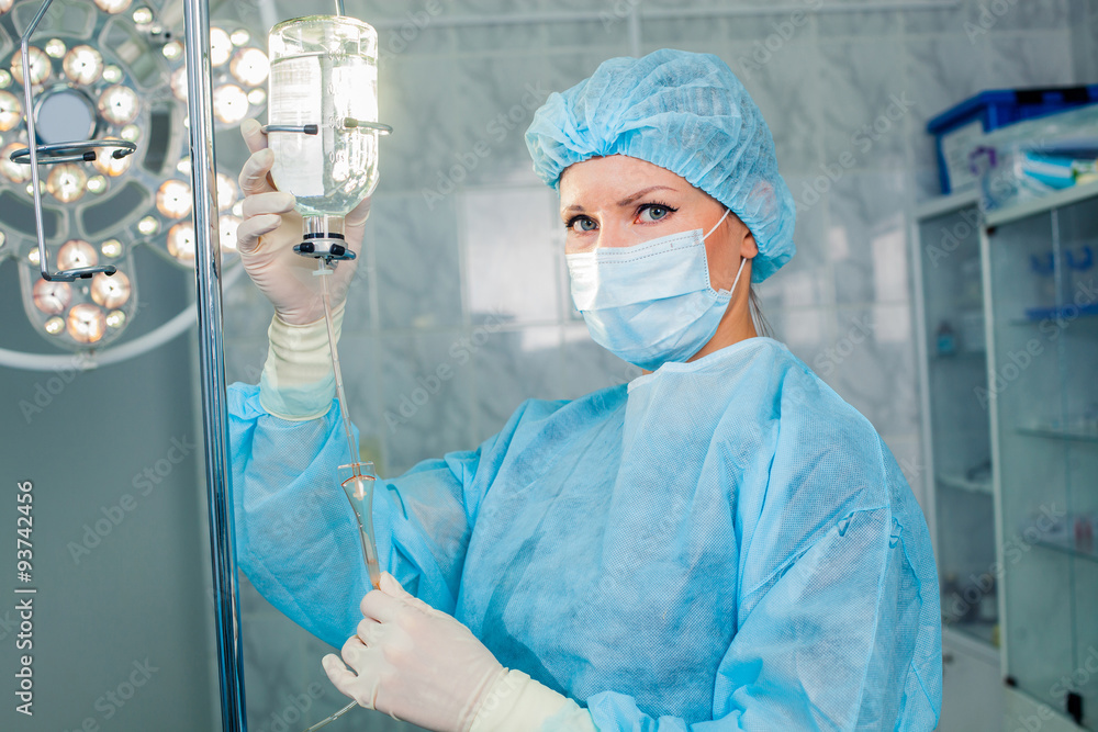 Nurse adjusting infusion bottle with against background of the Nurse adjusting infusion bottle with against background of the