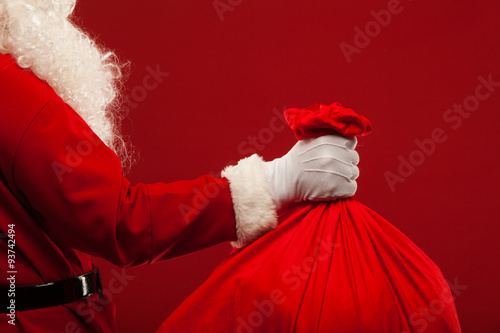 santa claus with big bag on shoulder glasses  red background