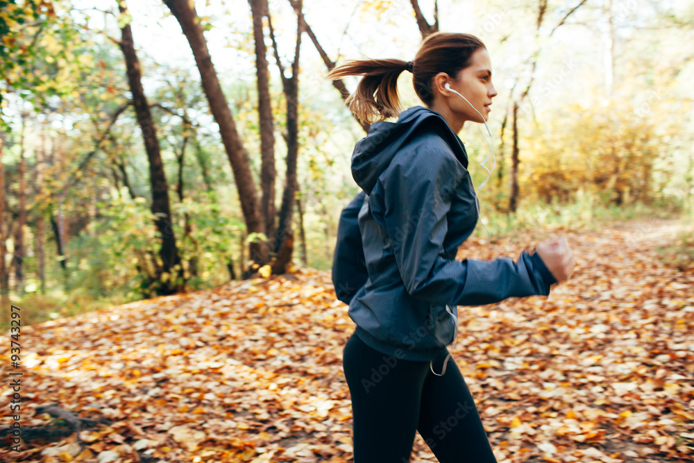  Runner woman jogging in autumn park. Motion blur effect