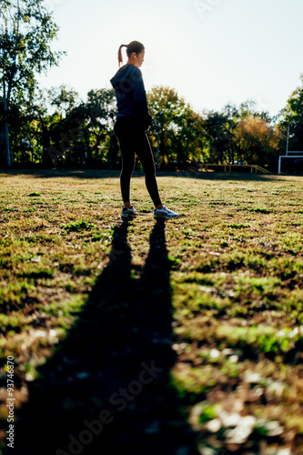 woman standing on sport yard against the sun