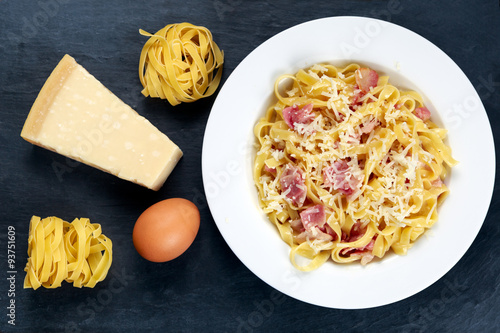 Classic Pasta carbonara Italian. decorated with tangliatelle spaghetti, egg and Parmesan Cheese on blue background. photo