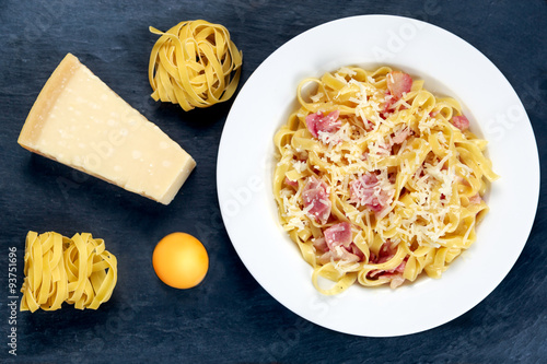 Classic Pasta carbonara Italian. decorated with tangliatelle spaghetti, egg and Parmesan Cheese on blue background. photo