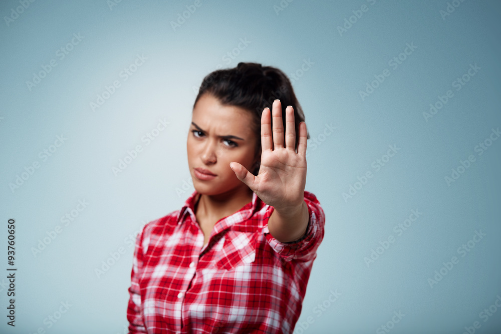 Angry woman gesturing stop sign over isolated backgound. Focus on hand. Angry woman gesturing stop sign over isolated backgound. Focus on hand.