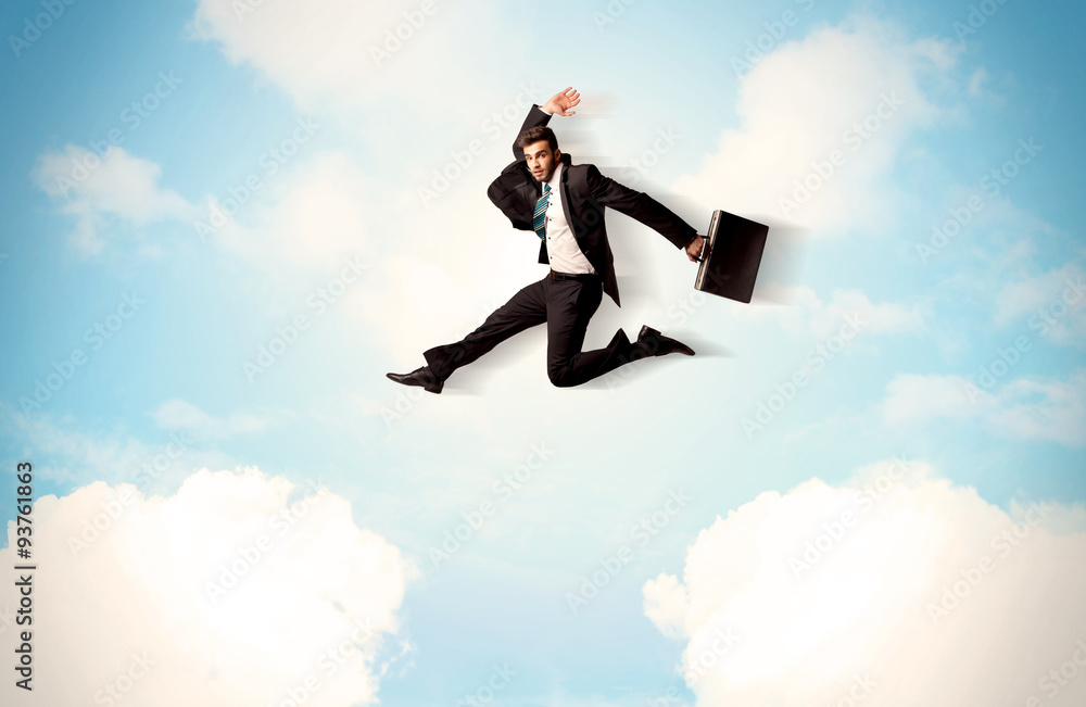 Business person jumping over clouds in the sky
