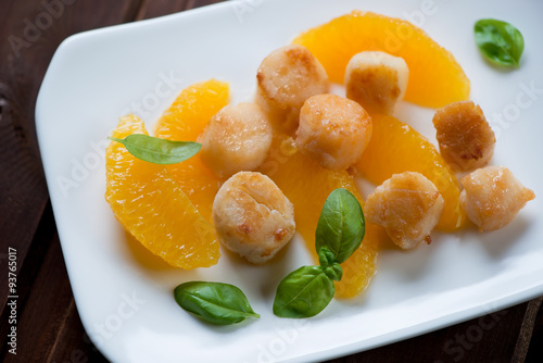 Roasted sea scallops with orange fillet, selective focus