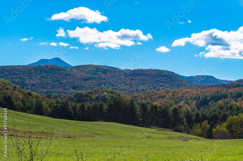 meadows and fields with hills in fall foliage color and Camels Hump against the sky 