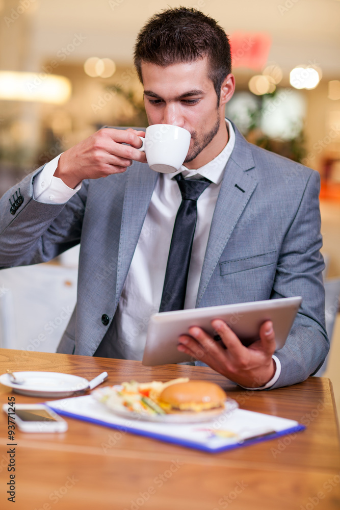 businessman in the restaurant drinking coffee and working on dig businessman in the restaurant drinking coffee and working on dig