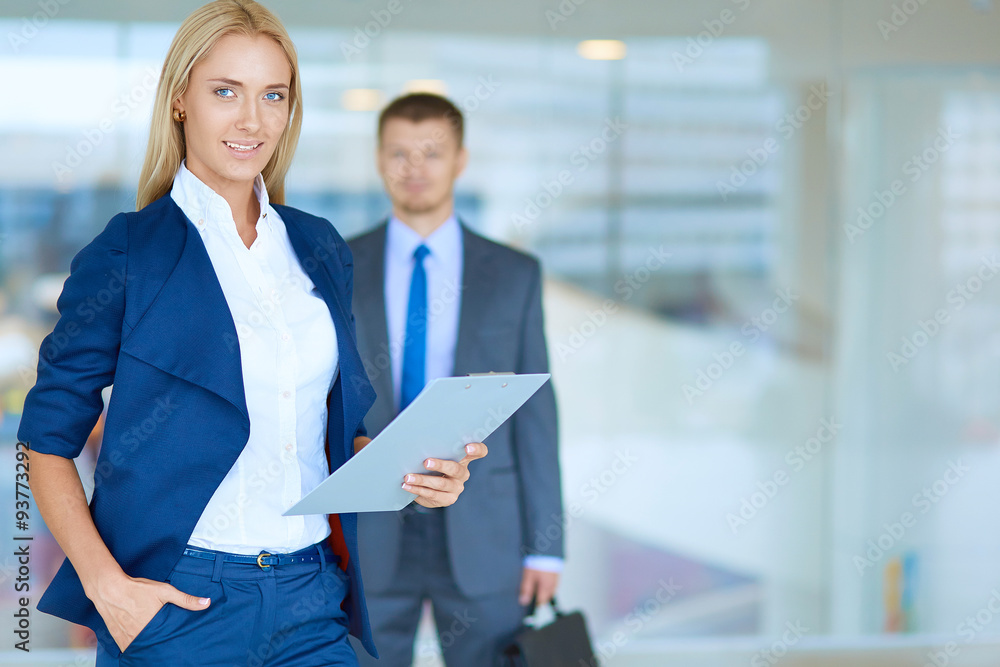 © lenets_tan - Businesswoman standing in office , holding documents in hand