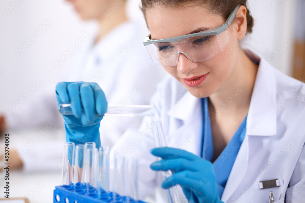 Woman researcher is surrounded by medical vials and flasks Woman researcher is surrounded by medical vials and flasks