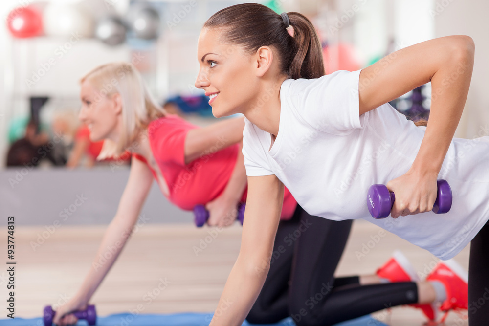 Attractive young women are training with weights Attractive young women are training with weights