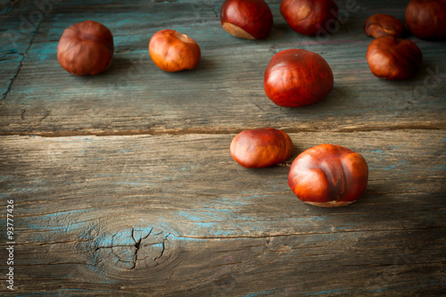 ripe chestnuts on a wooden background