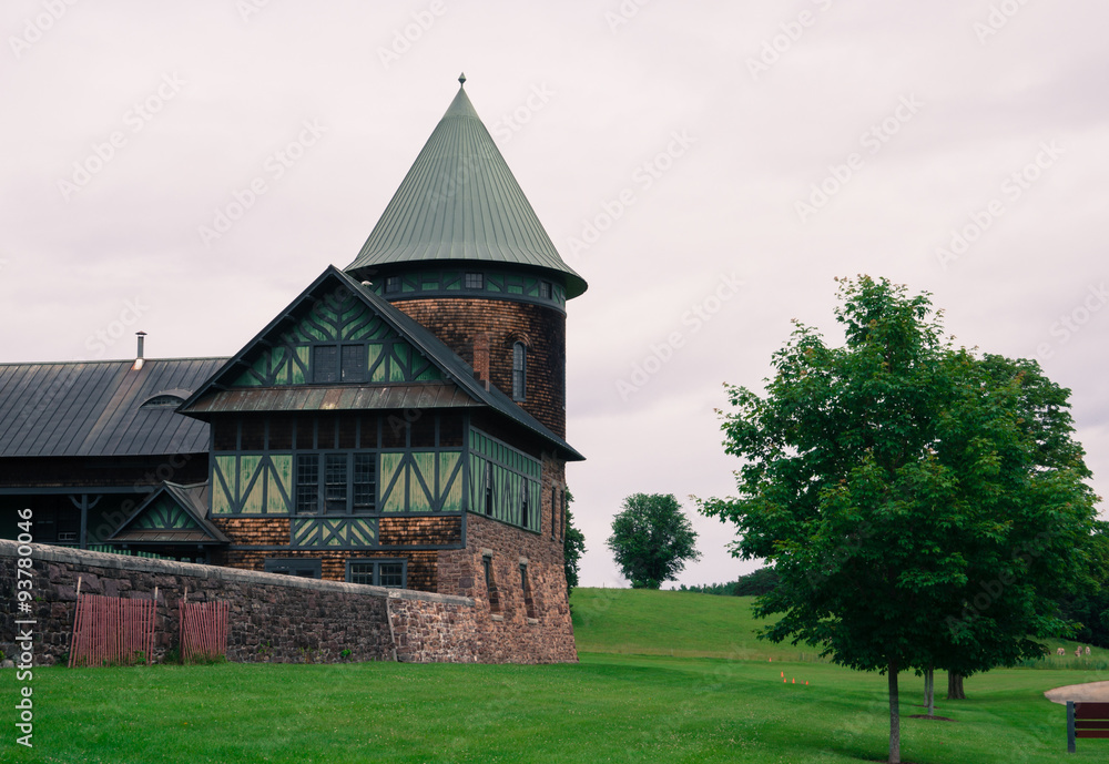 a corner of the historic barn built in the early 1900s shows architectural details and quality with wood shingle, green wooden panels and design and metal roofs on tower and barn a corner of the historic barn built in the early 1900s shows architectural details and quality with wood shingle, green wooden panels and design and metal roofs on tower and barn