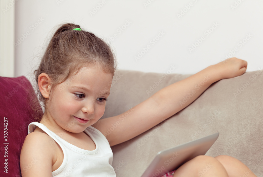 cute little girl playing with tablet computer at home cute little girl playing with tablet computer at home