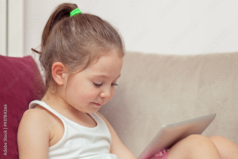 cute little girl playing with tablet computer at home cute little girl playing with tablet computer at home