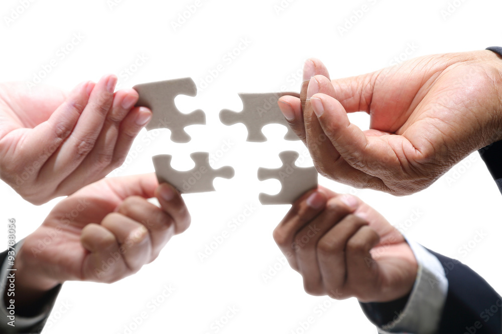 Business people using jigsaw puzzle for joy Business people using jigsaw puzzle for joy