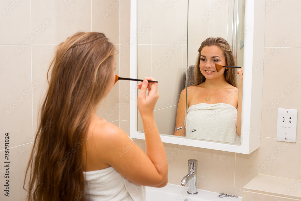 young woman applying makeup in the bathroom Stock Photo Adobe Stock