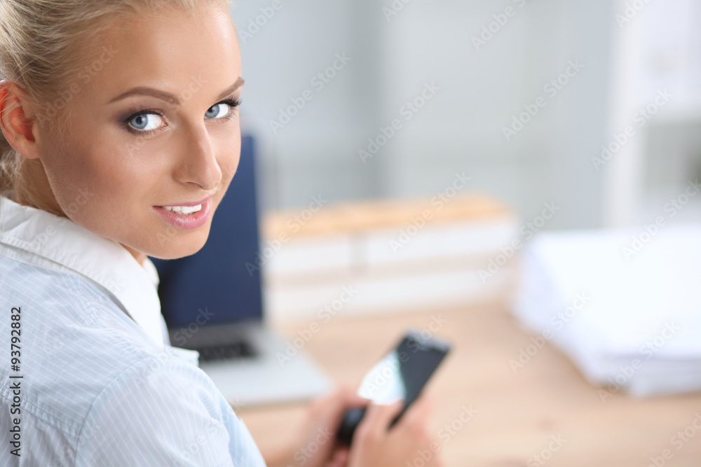 Businesswoman sending message with smartphone sitting in the Businesswoman sending message with smartphone sitting in the