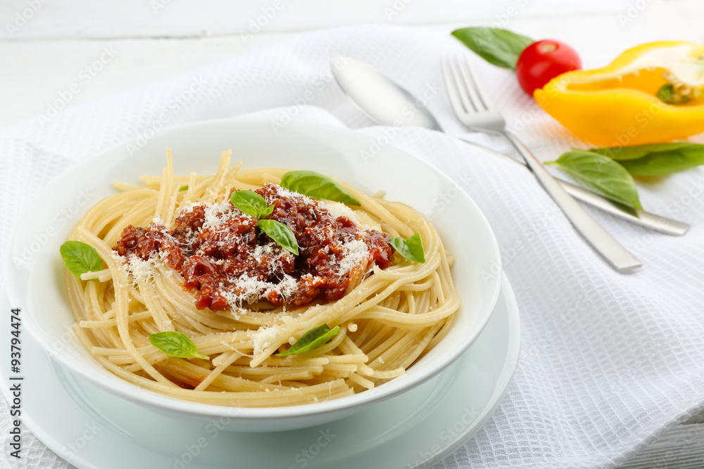 Spaghetti Bolognese with parmesan cheese in white bowl, on color wooden background Spaghetti Bolognese with parmesan cheese in white bowl, on color wooden background