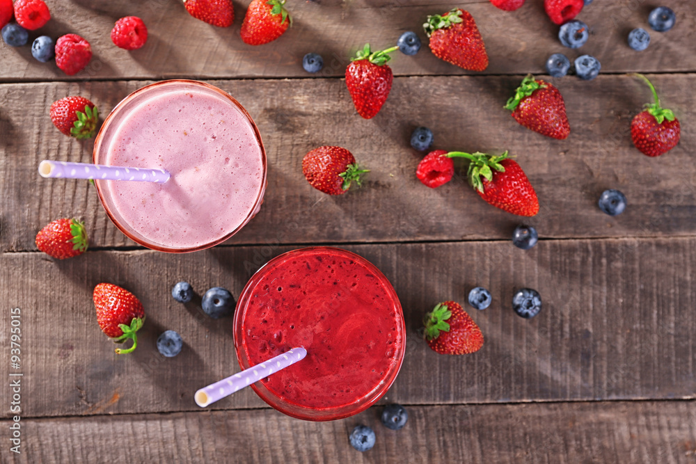 Glasses of berry smoothie on wooden table, top view Glasses of berry smoothie on wooden table, top view
