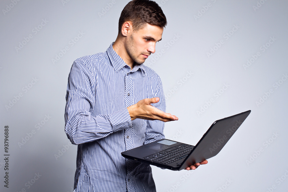 portrait of business man with a laptop on a gray background portrait of business man with a laptop on a gray background