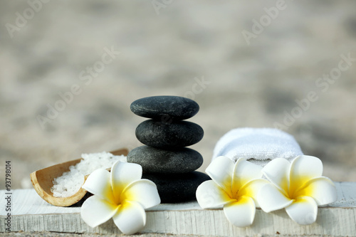 Spa composition with flowers on sand beach close up