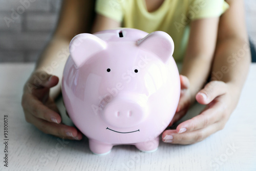 Little girl with her mum and pig moneybox closeup